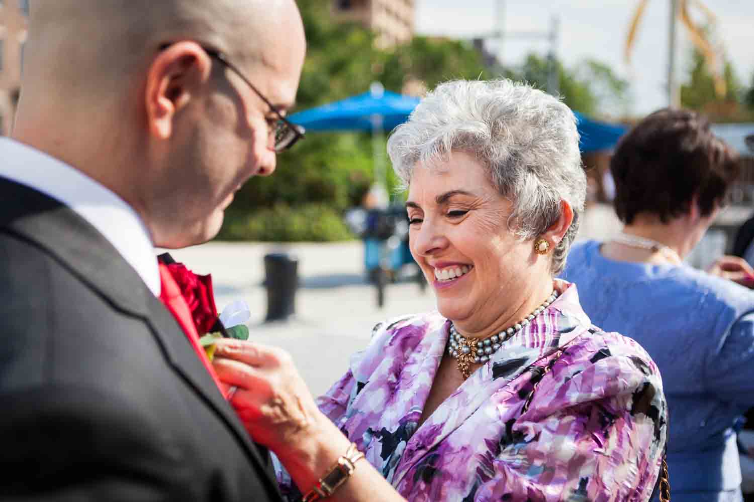 Mother putting boutonniere on groom
