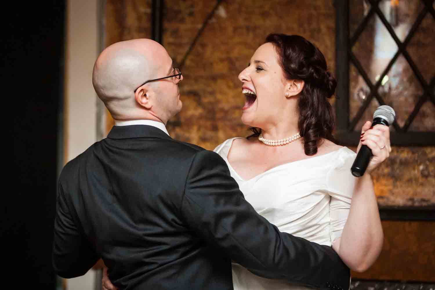 Bride and groom laughing at each other after song