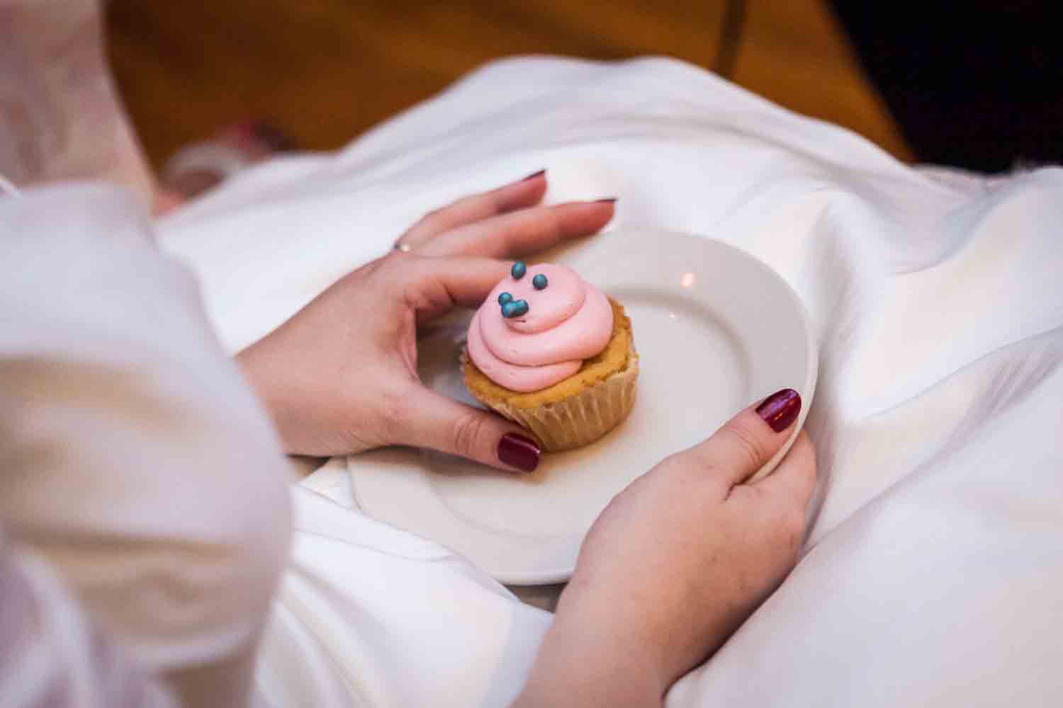 Close up on bride's hands holding cupcake