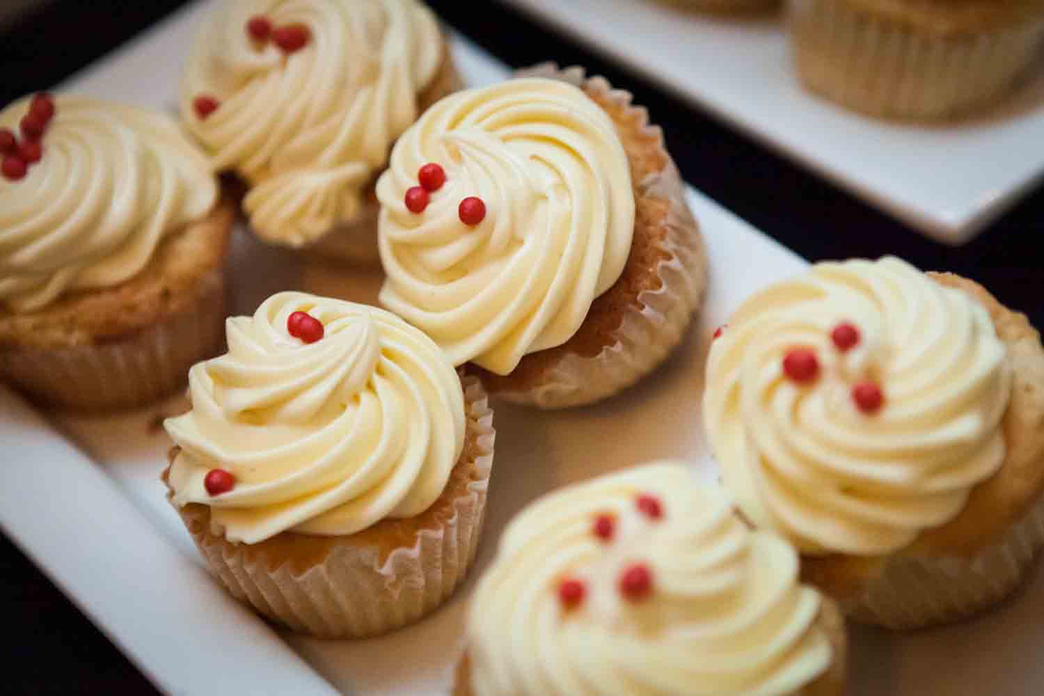 Close up on cupcakes with yellow frosting and red sprinkles