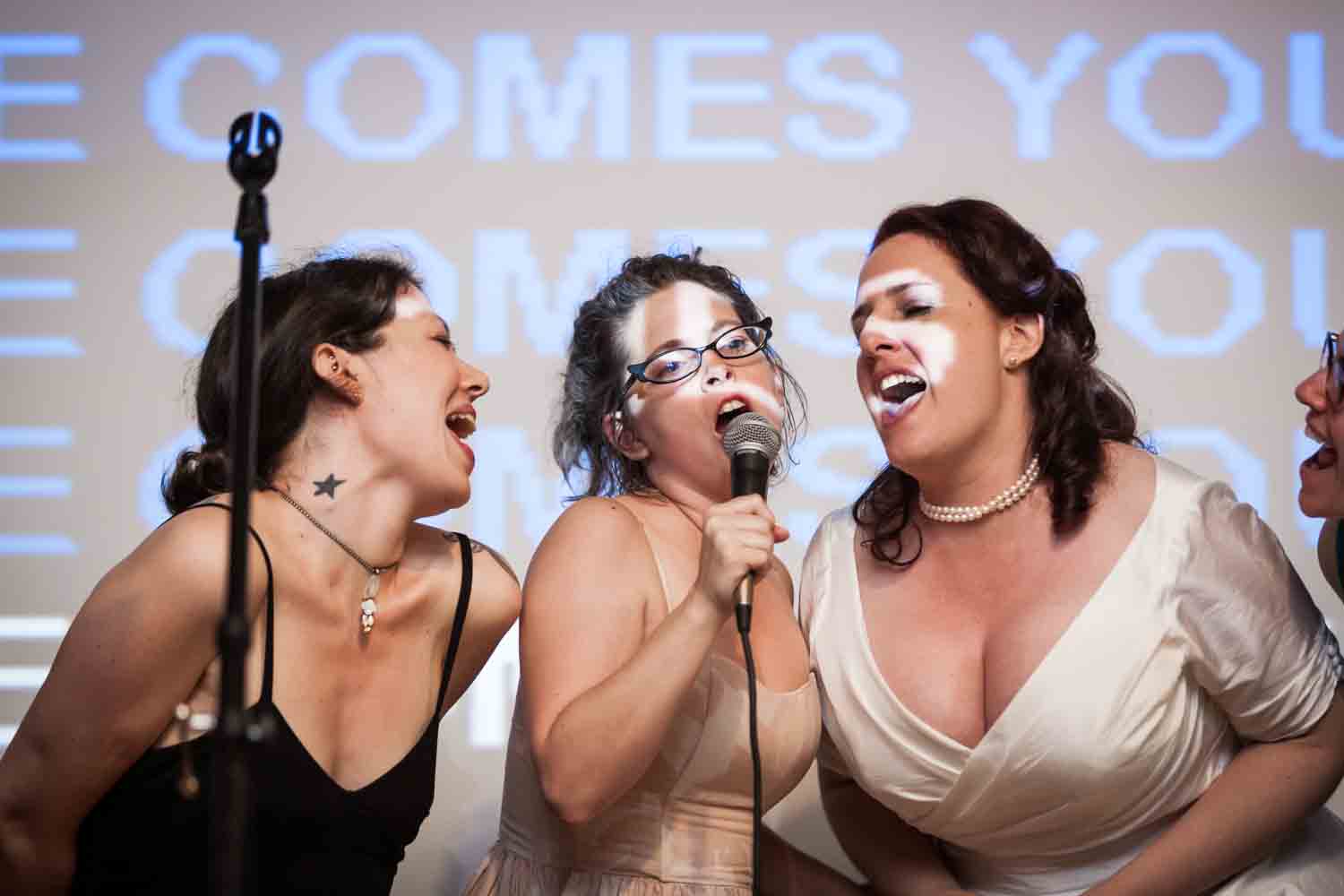Bride singing karaoke with two female guests at a DUMBO wedding