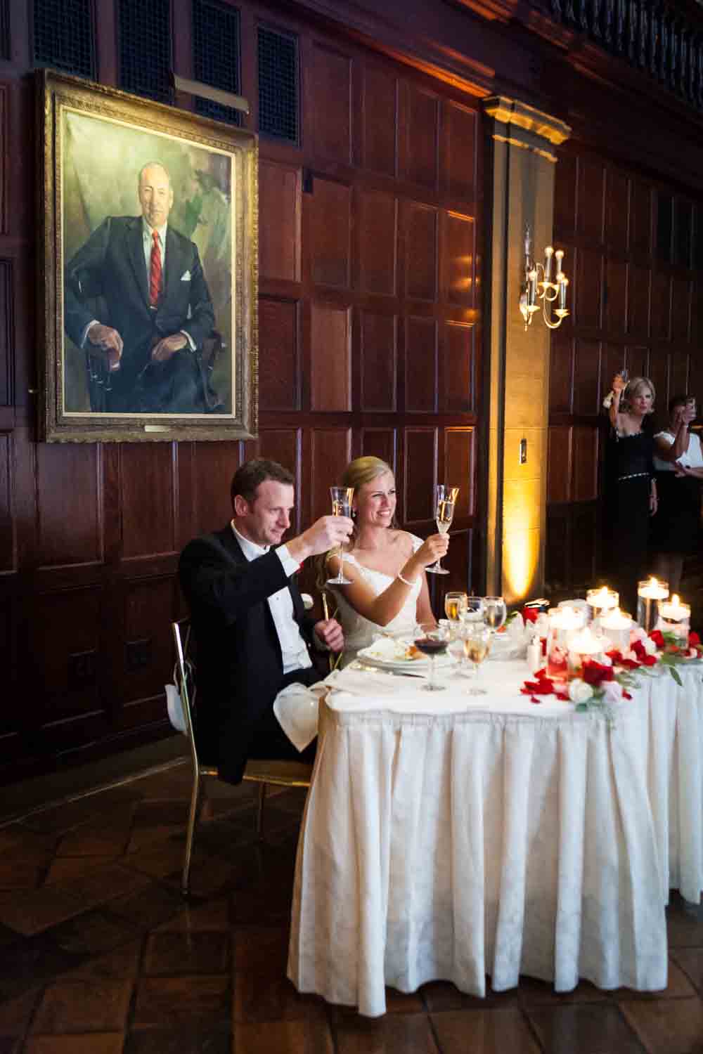 Bride and groom raising champagne glasses at a Harvard Club NYC wedding