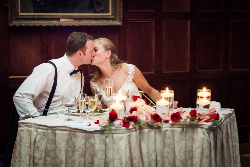 Bride and groom kissing at sweetheart table at a Harvard Club NYC wedding