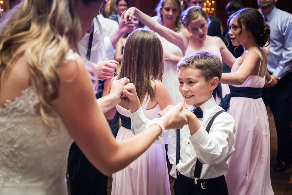 Bride dancing with young boy wearing bow tie