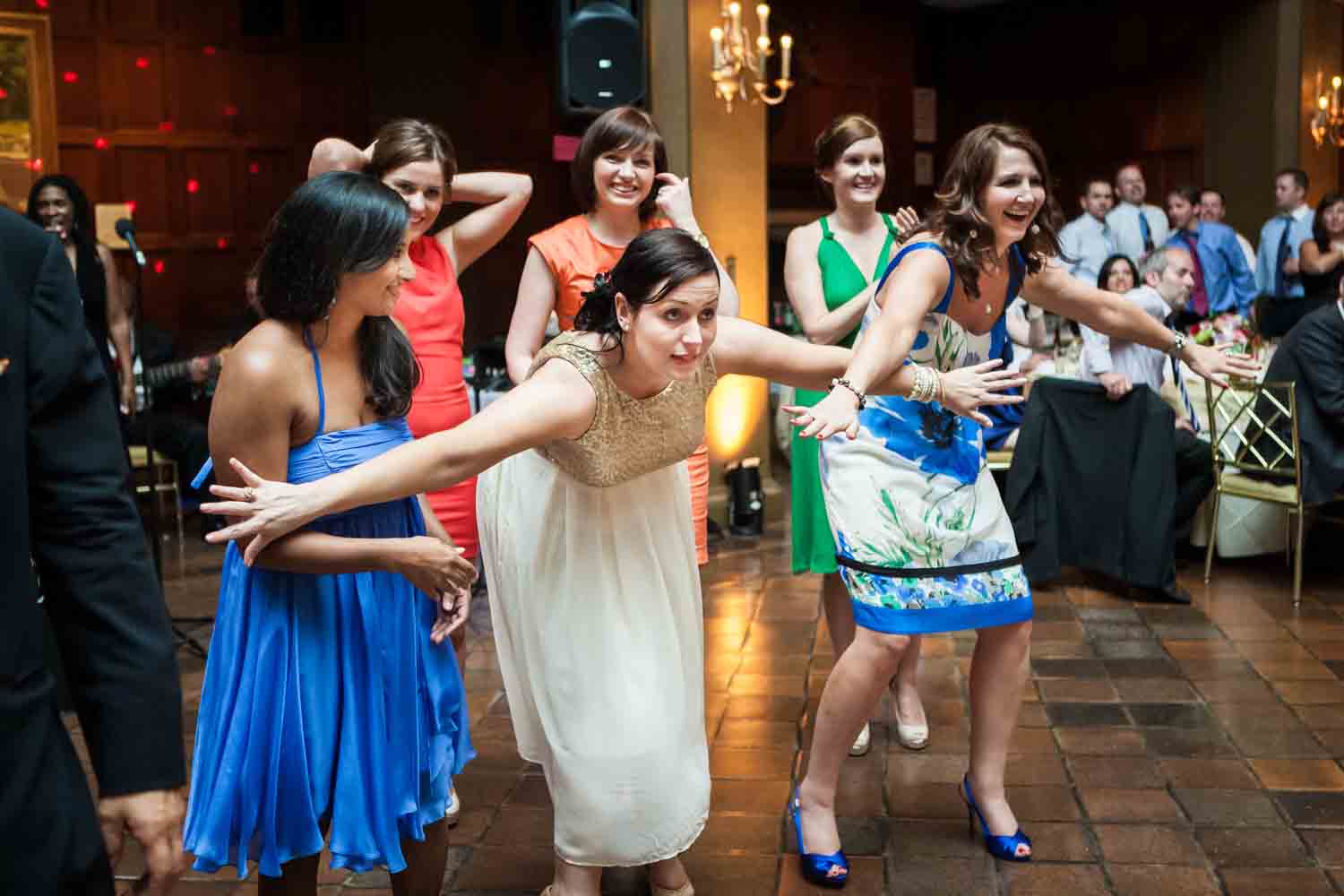Woman holding back other female guests during bouquet toss
