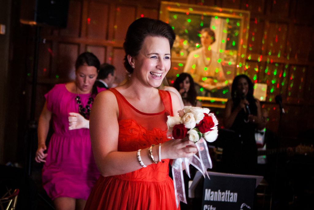 Female guest holding bouquet and wearing red dress