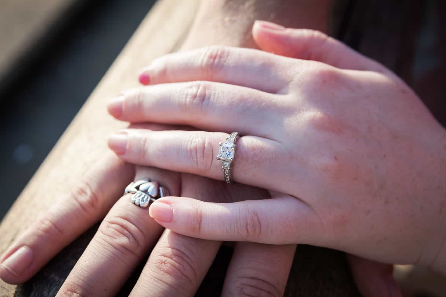 Close up on hands of couple wearing engagement rings
