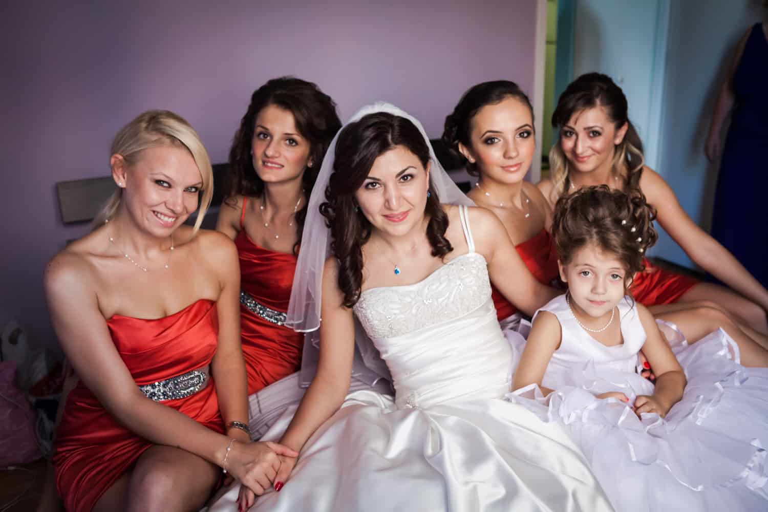 Bride and bridesmaids sitting on bed