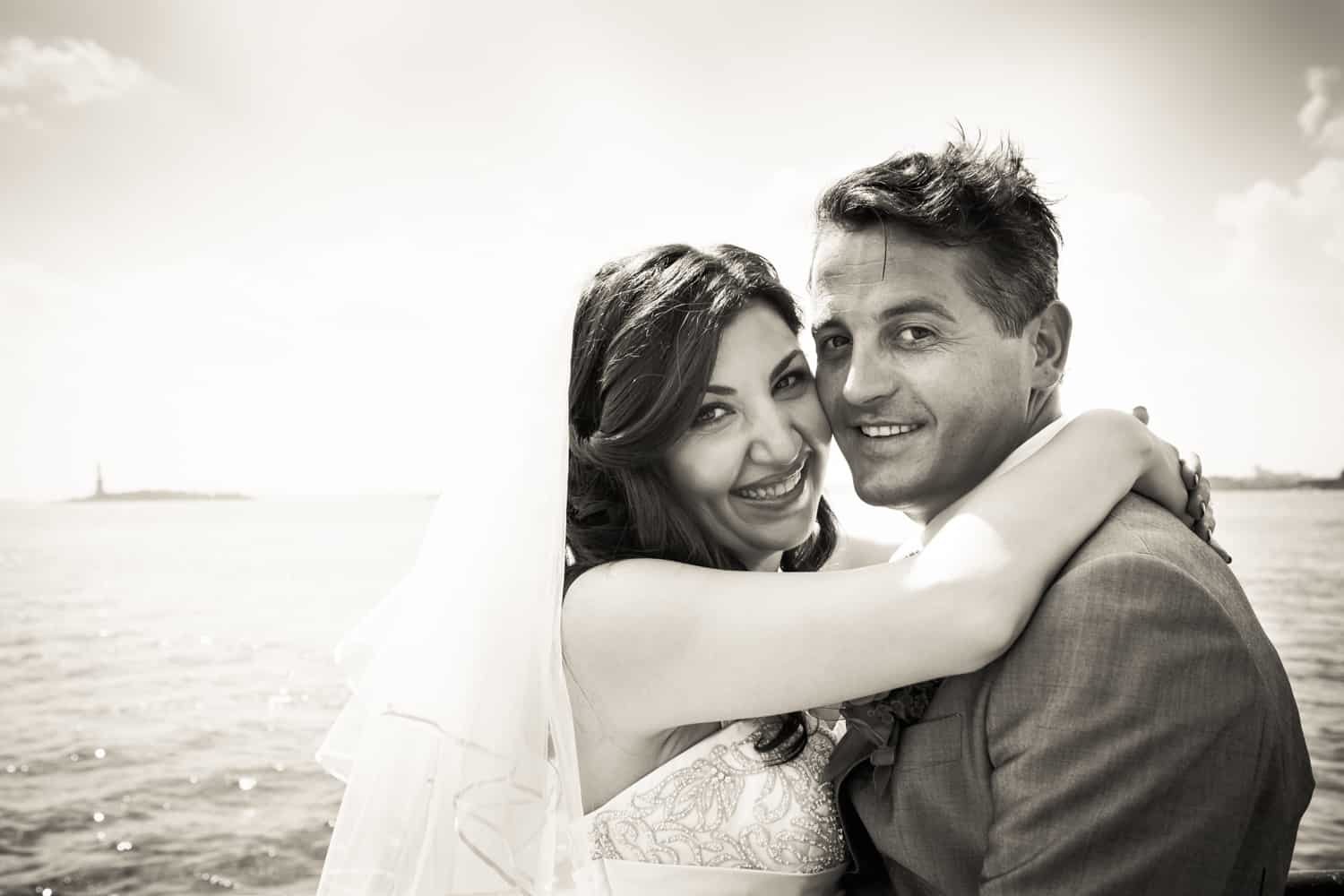 Black and white photo of bride and groom by waterfront