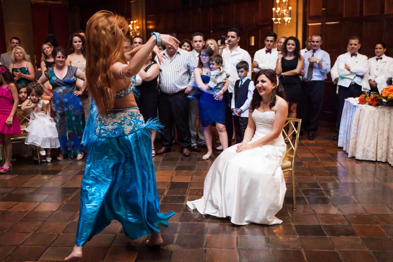 Bride sitting in front of belly dancer at a Harvard Club wedding