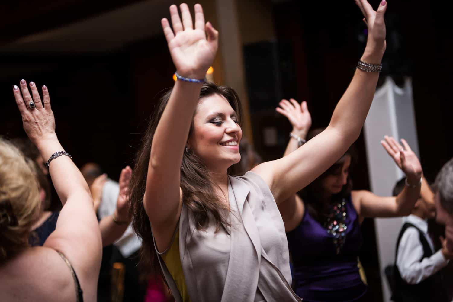 Female guest dancing with hands raised at a Harvard Club wedding