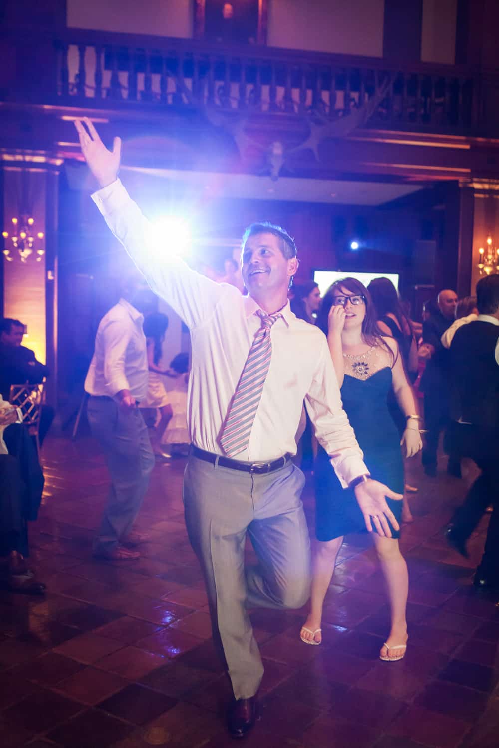 Groom dancing with hands raised at a Harvard Club wedding