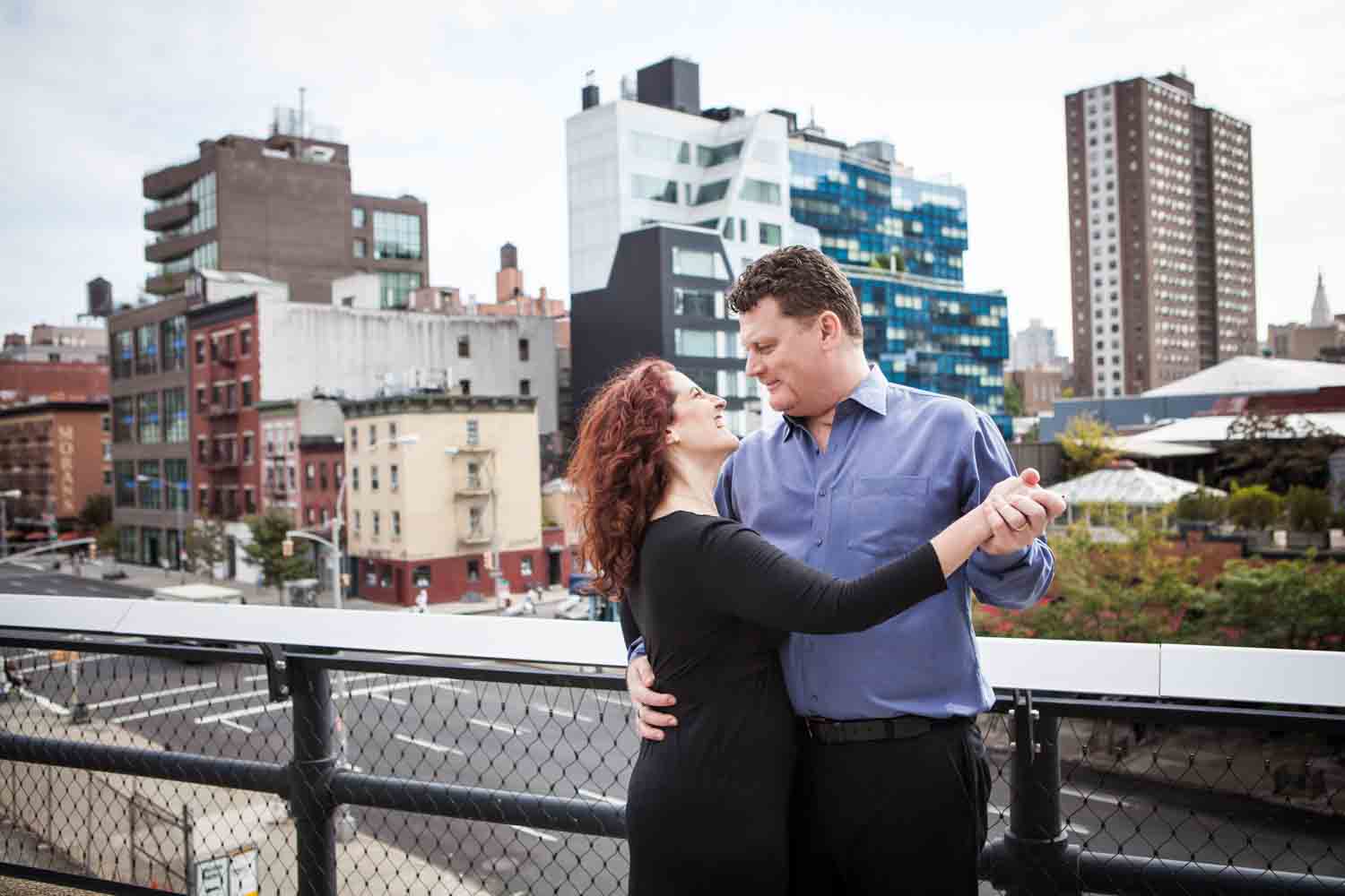 Couple dancing together on the High Line observation deck with NYC street in background