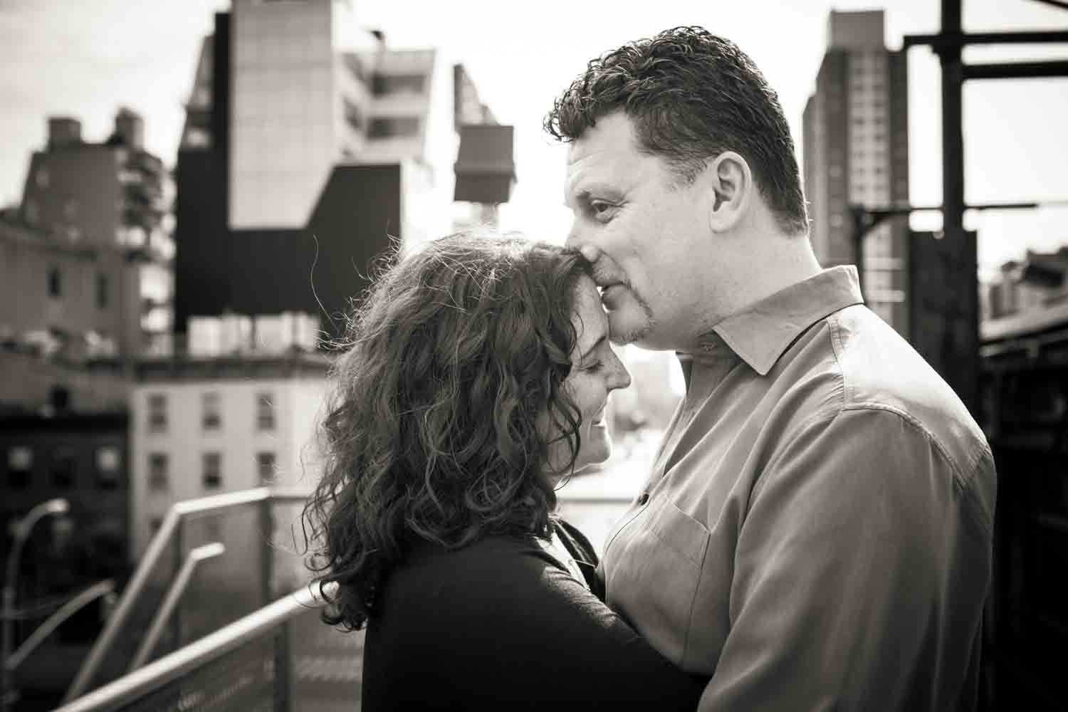 Black and white photo of man kissing woman on the forehead