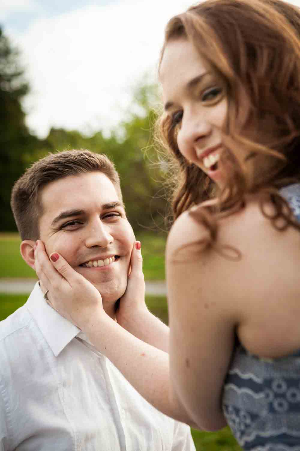 Woman holding man's face at a Lyndhurst Mansion engagement photoshoot