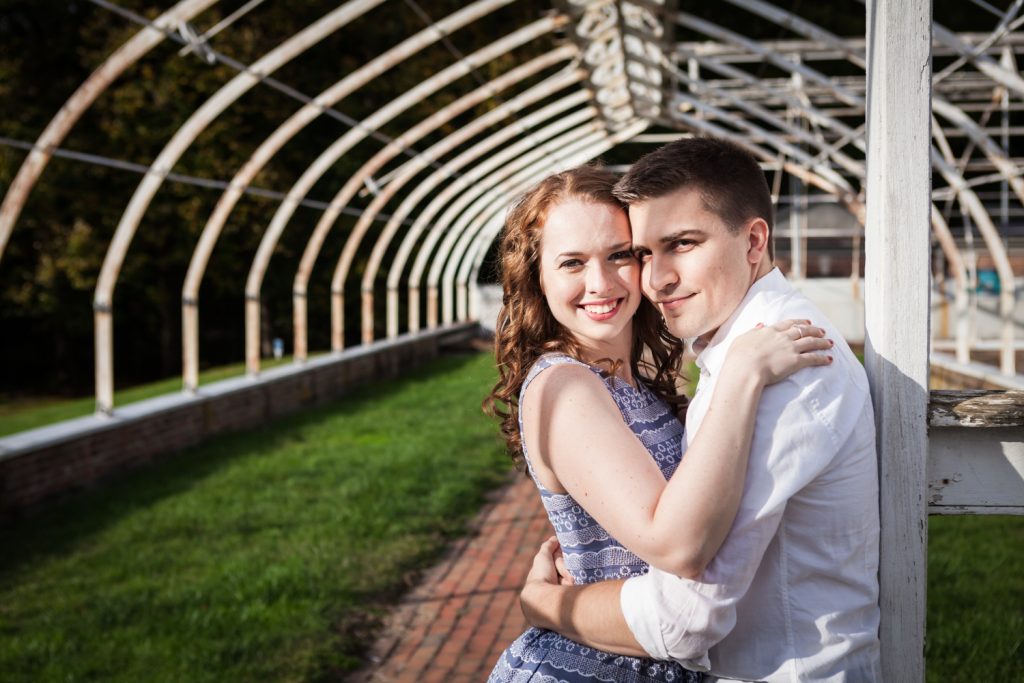 Couple hugging in dilapidated greenhouse at a Lyndhurst Mansion engagement photoshoot