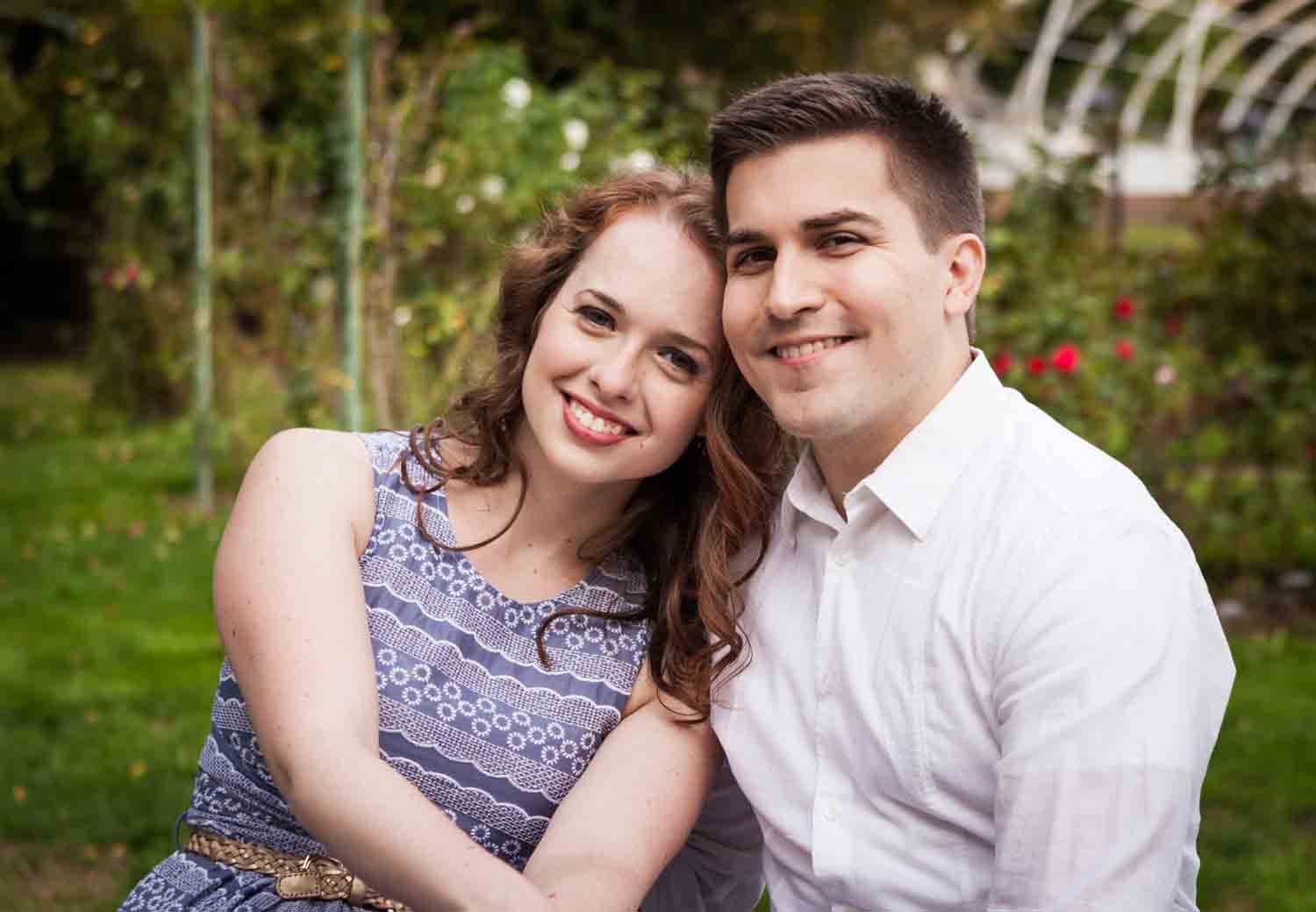 Couple in front of rose bushes at a Lyndhurst Mansion engagement photoshoot