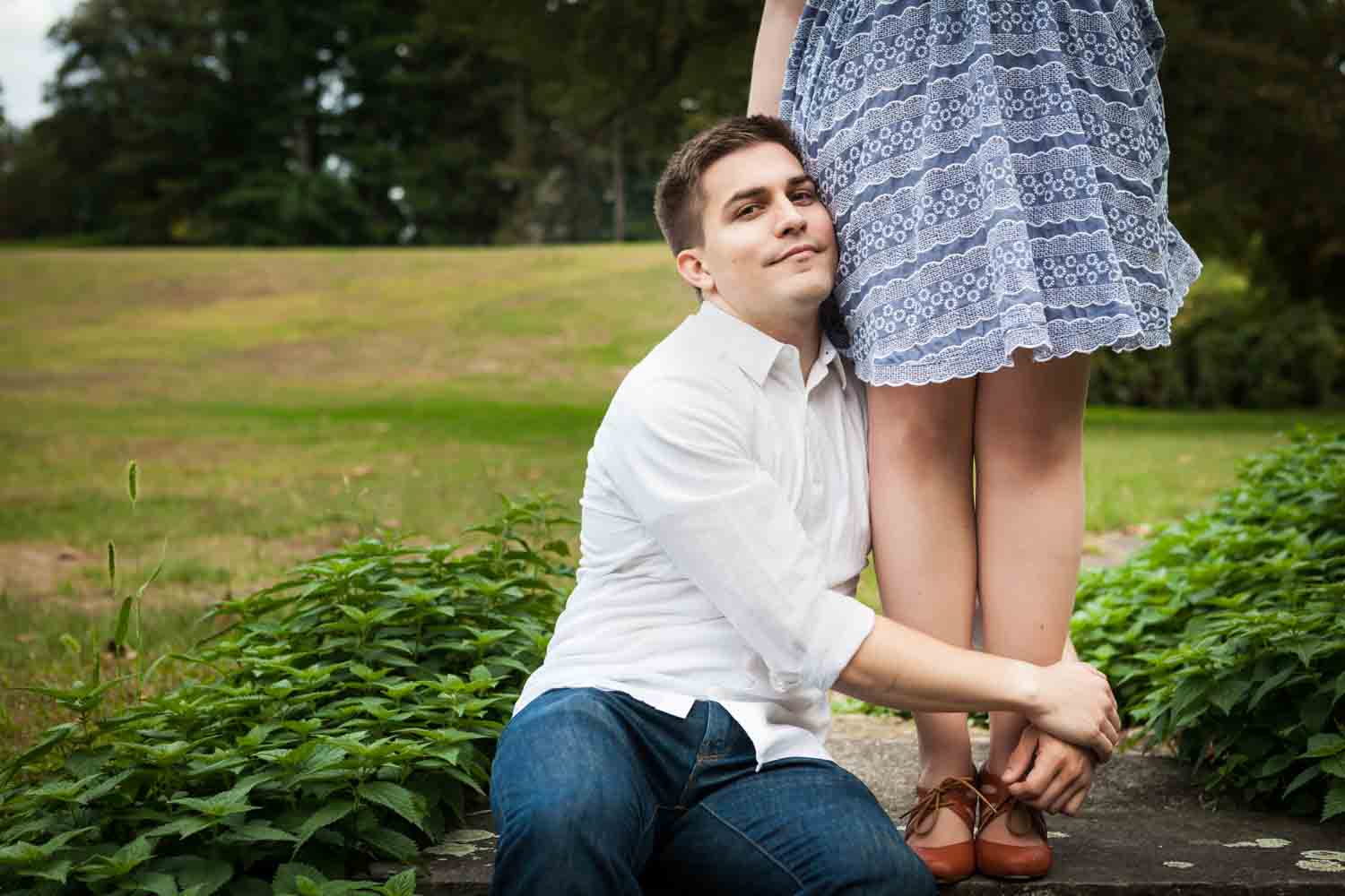 Man hugging woman's legs at a Lyndhurst Mansion engagement photoshoot