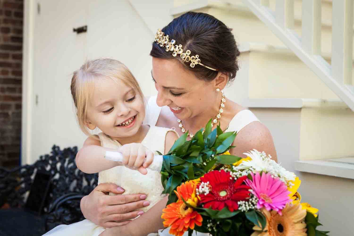 Bride playing with little flower girl