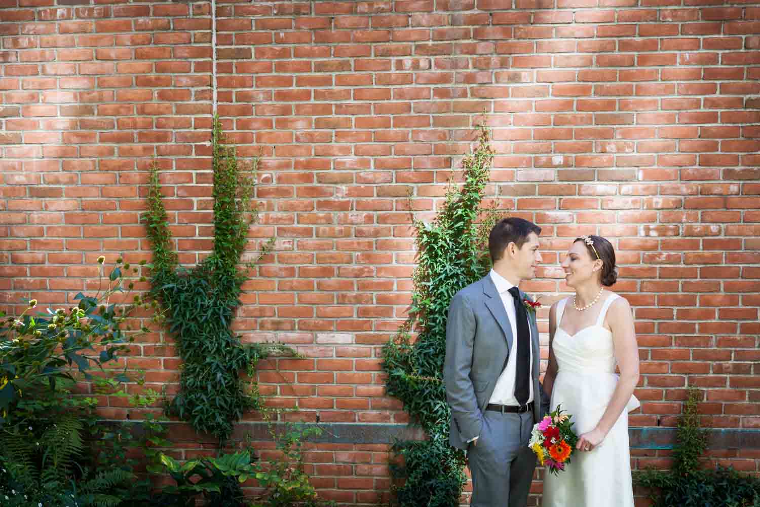 Merchant's House Museum wedding photos of bride and groom against brick wall