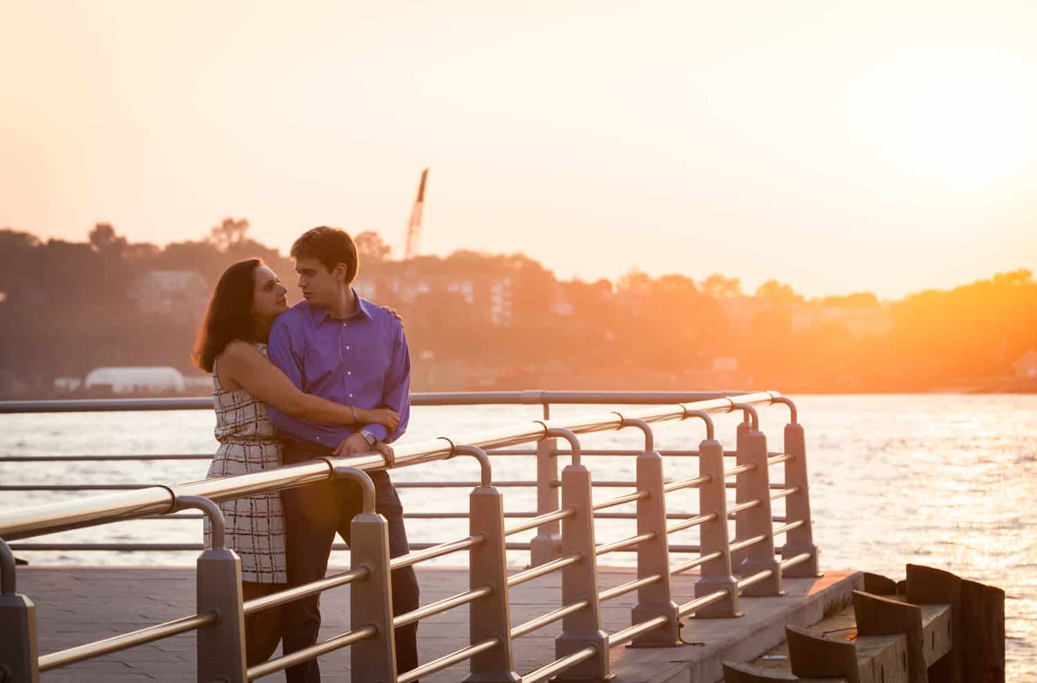 Couple on pier at sunset with Hudson River waterfront in background