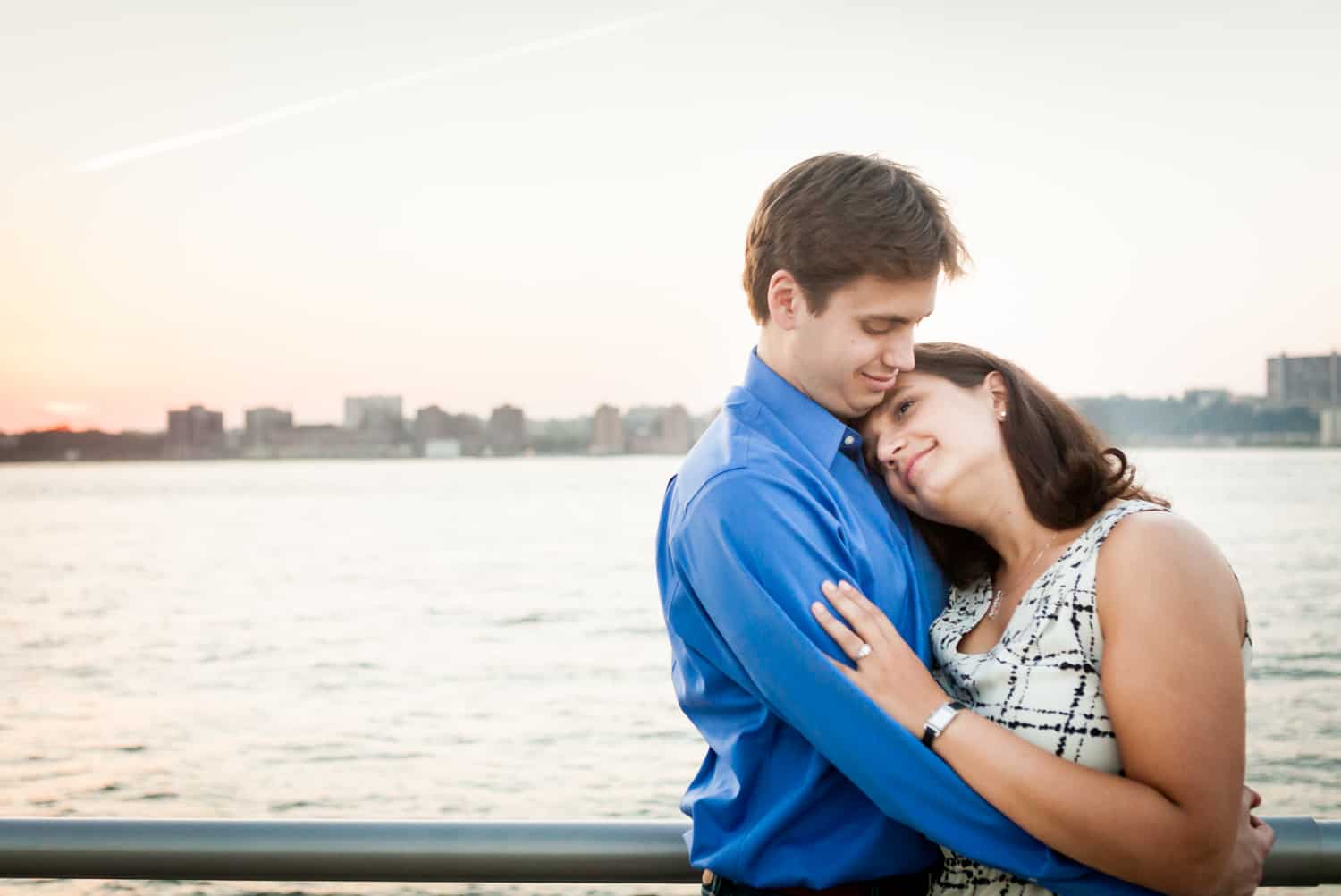 Couple hugging at sunset with Hudson River waterfront in background