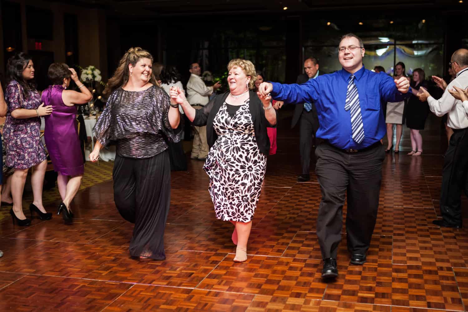 Three guests in line dance at a Nicotra's Ballroom wedding