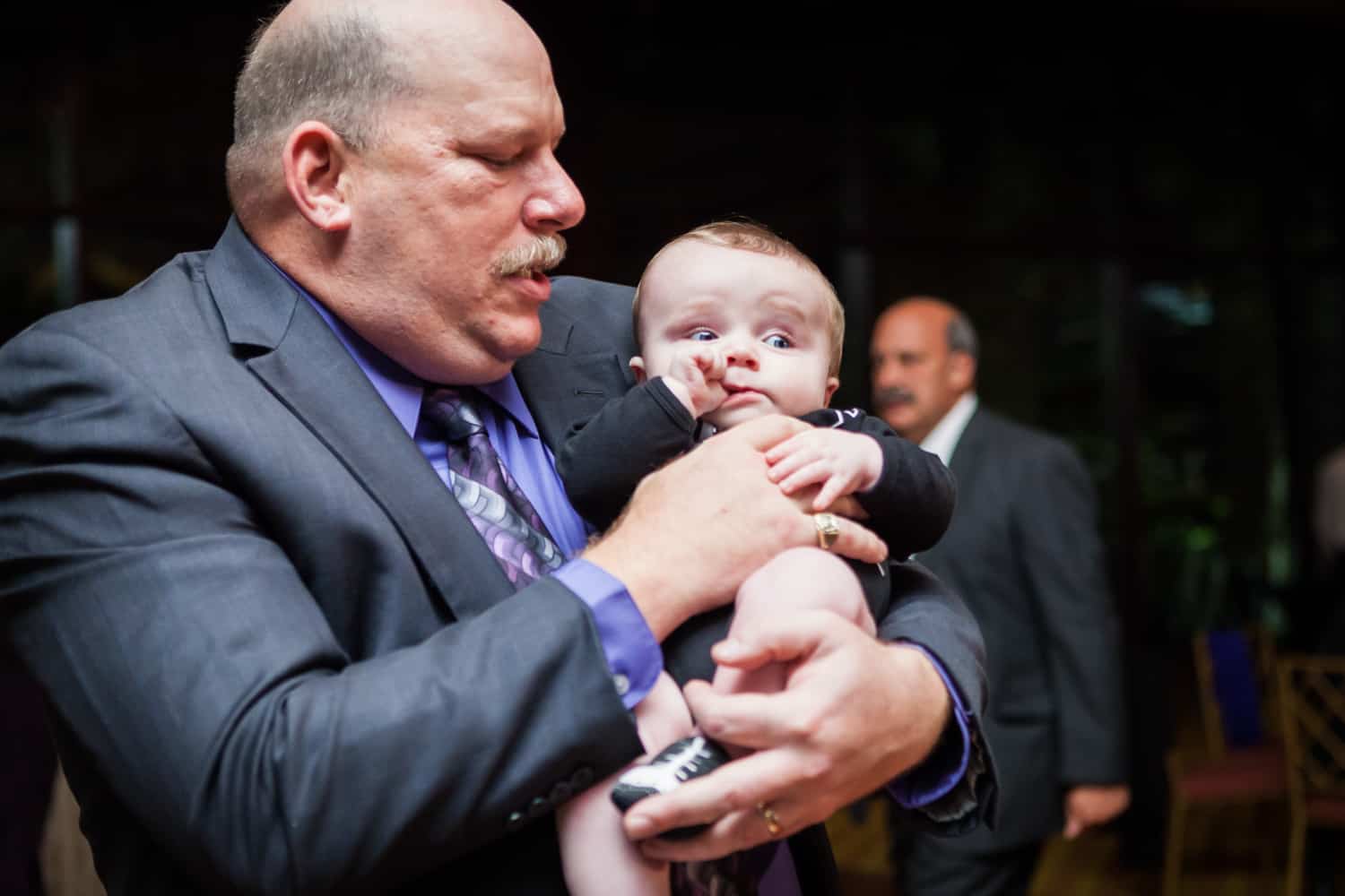 Grandfather holding little baby at a Nicotra's Ballroom wedding