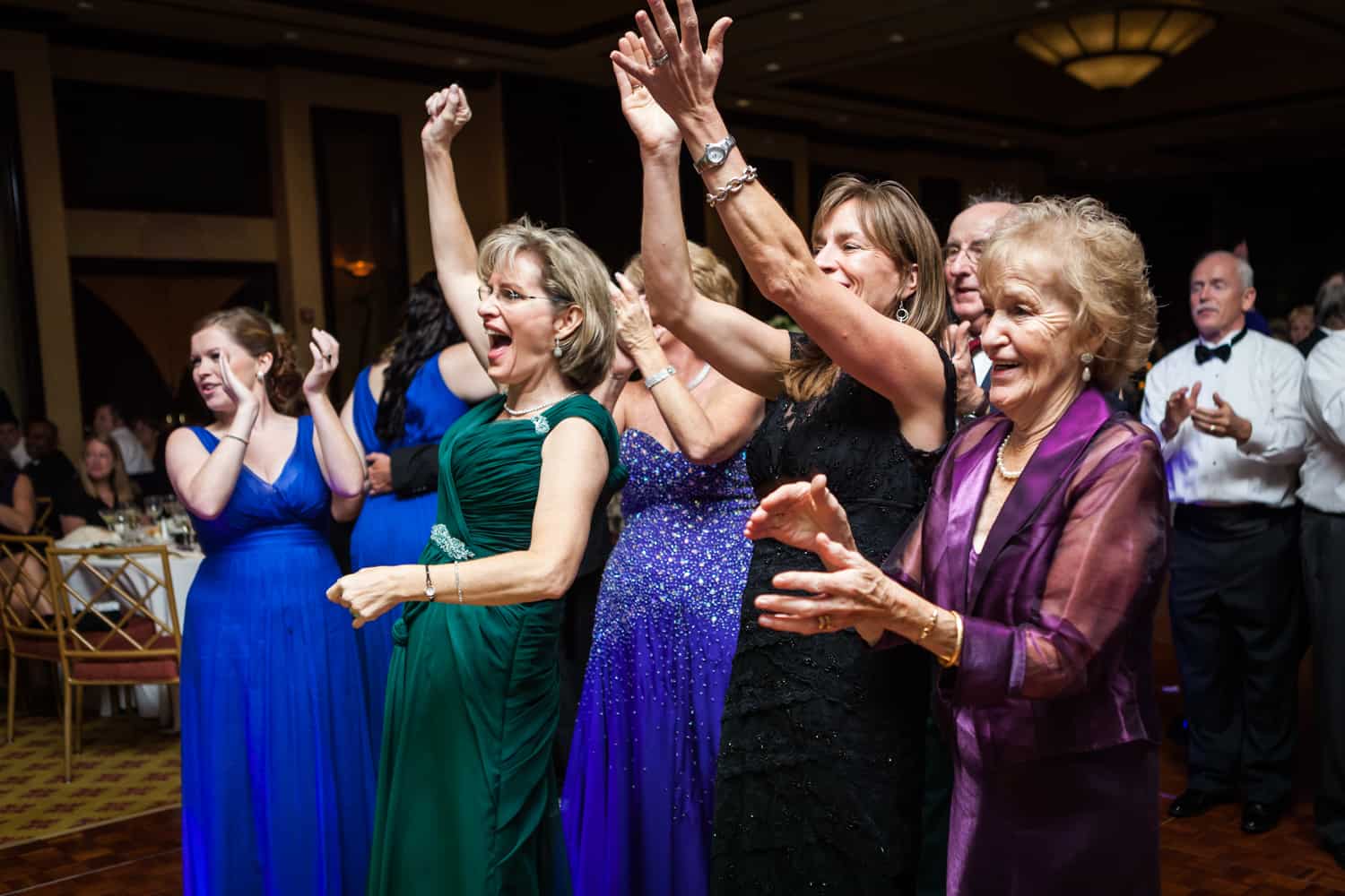 Guests cheering with arms raised at a Nicotra's Ballroom wedding