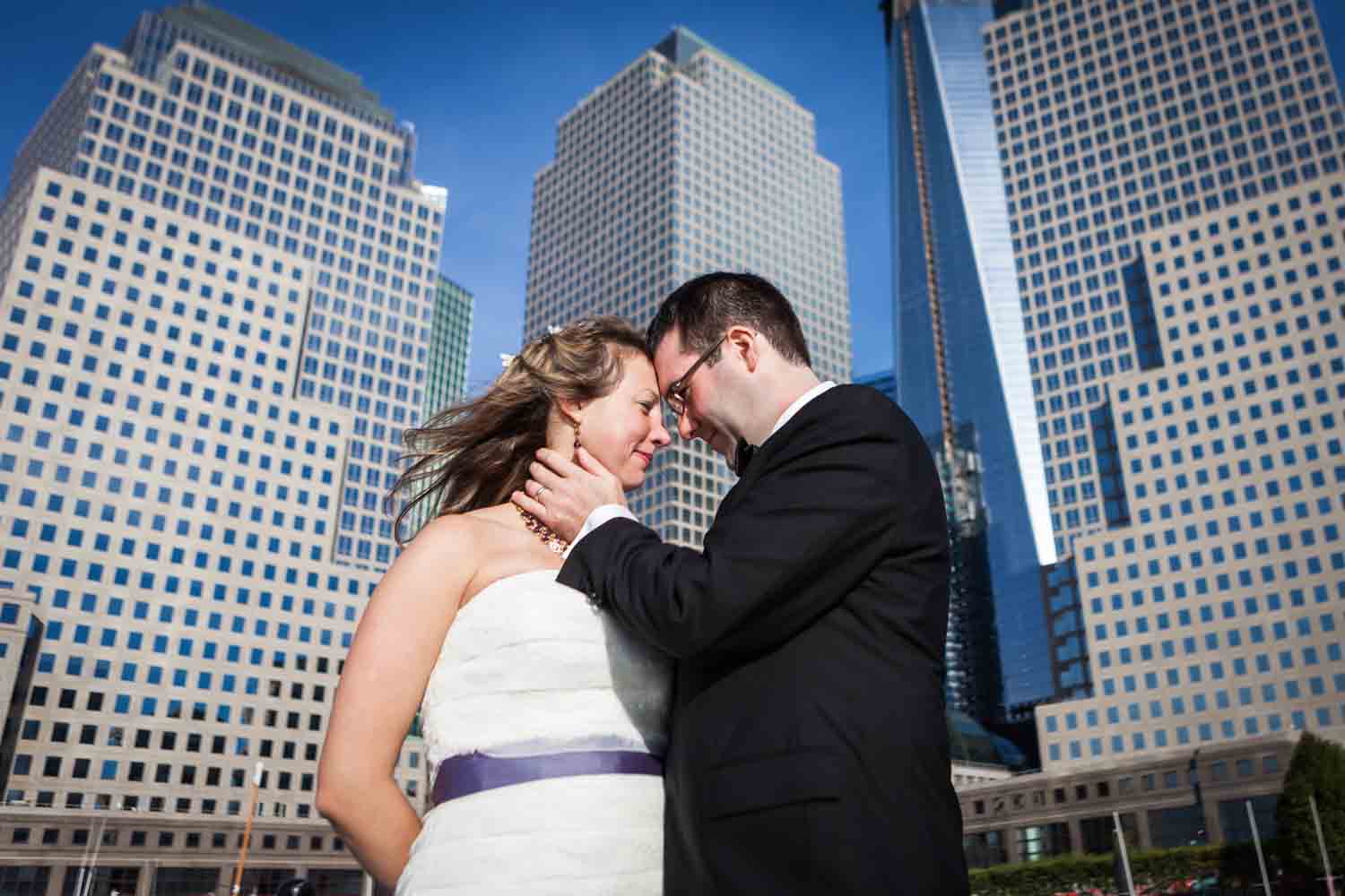 Bride and groom standing in front of downtown NYC buildings