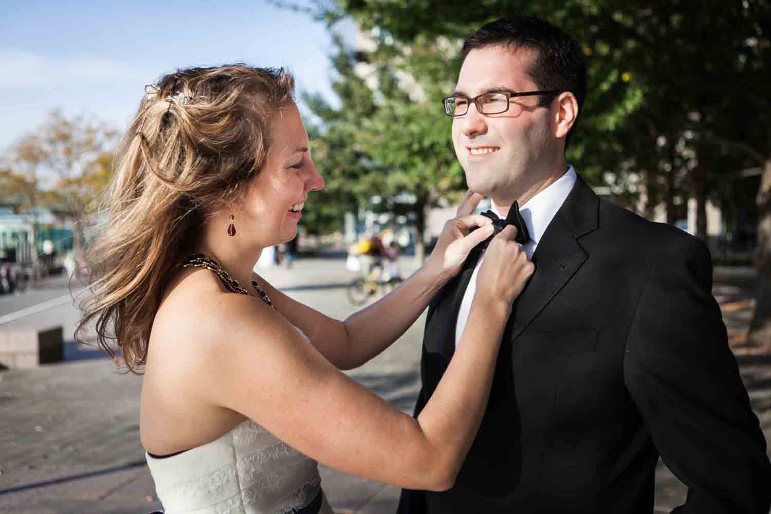 Bride adjusting groom's bow tie