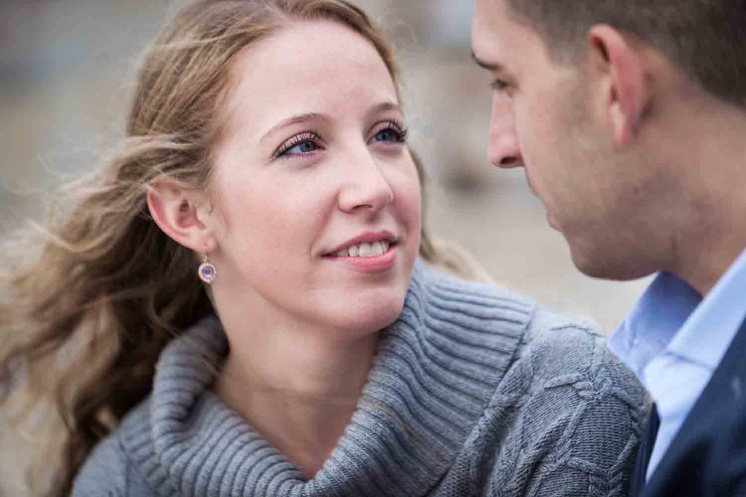Close up of woman looking at man during a Brooklyn Bridge Park engagement shoot