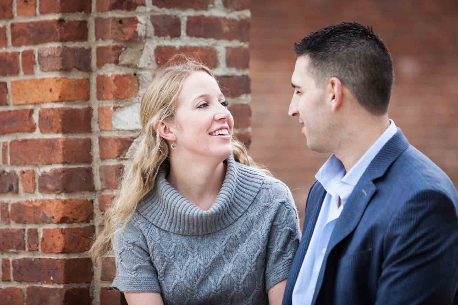 Couple sitting in brick archway during a Brooklyn Bridge Park engagement shoot