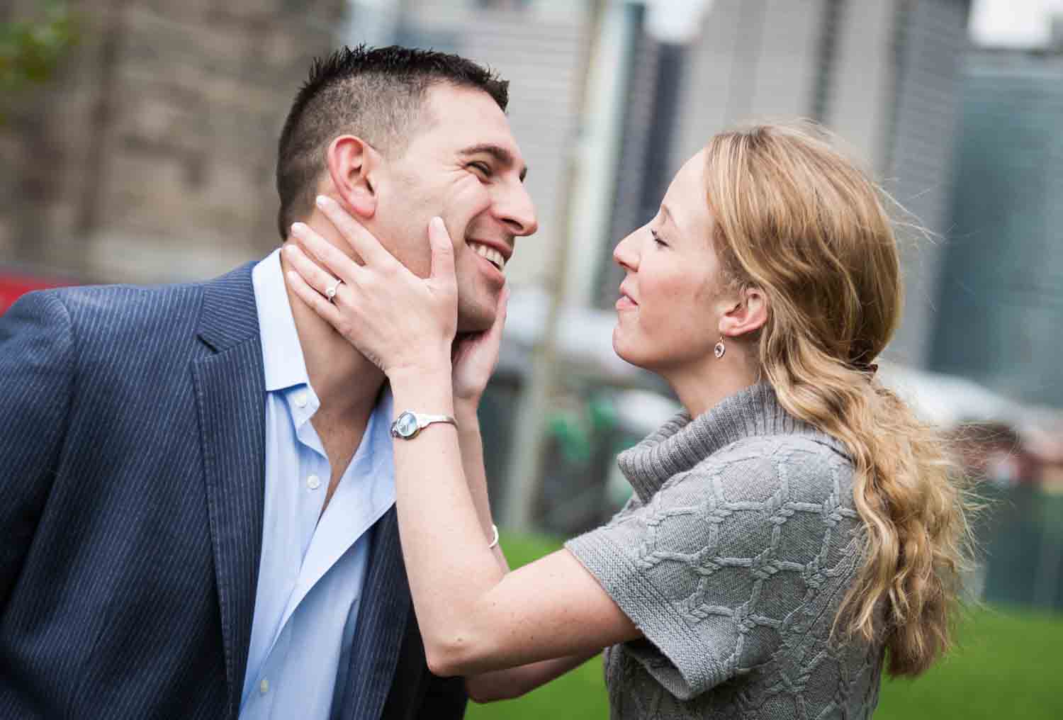Woman touching man's face during a Brooklyn Bridge Park engagement shoot