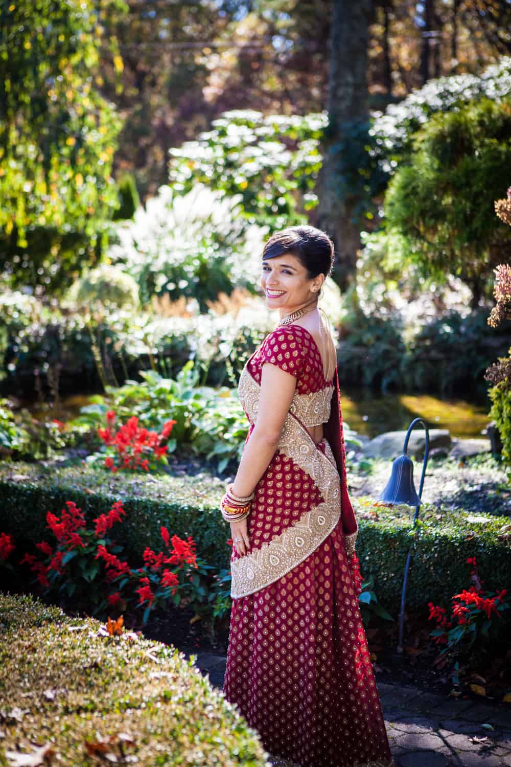 Bride in garden wearing red traditional sari at an East Wind Inn wedding
