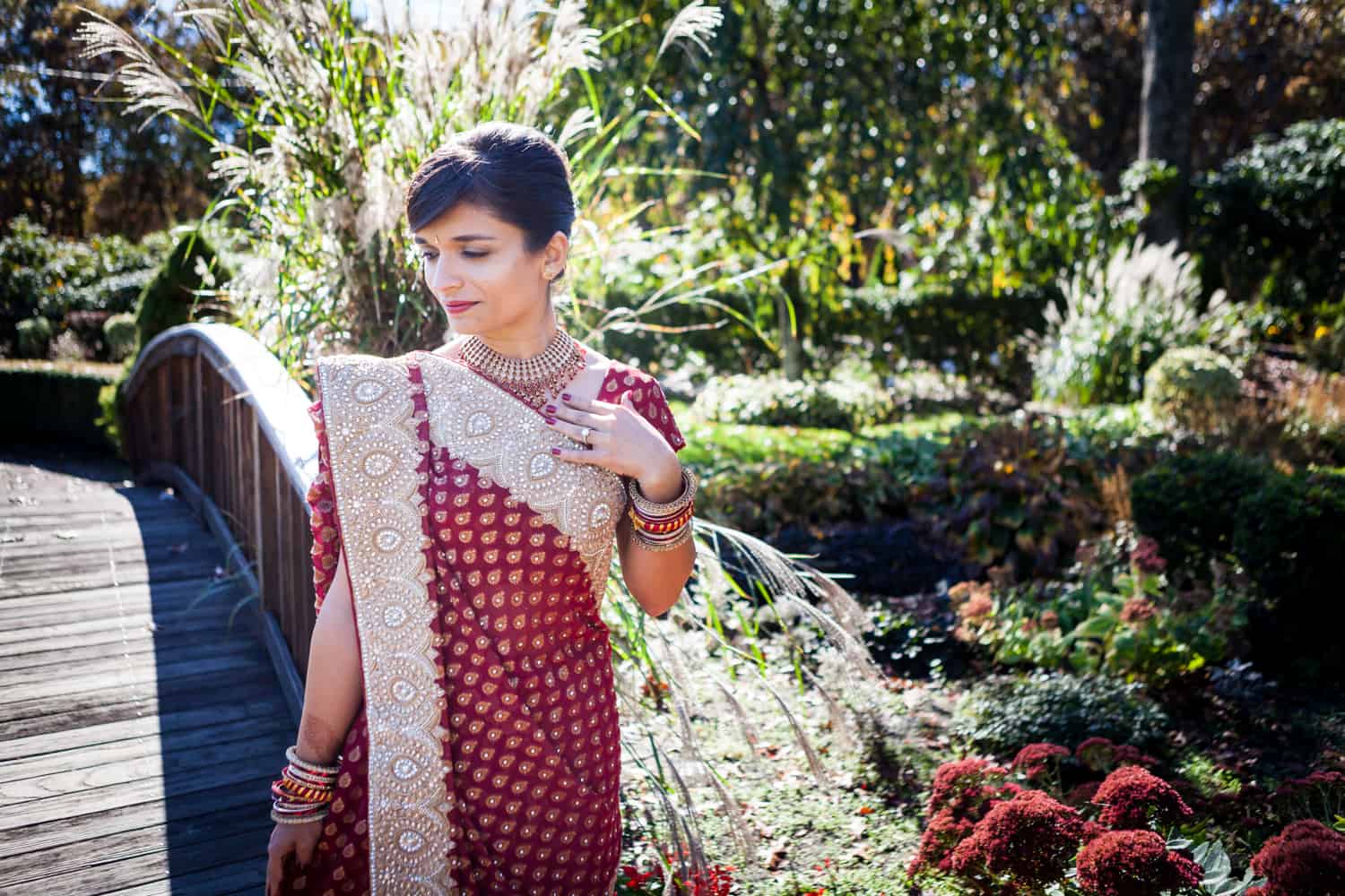 Bride in garden wearing red traditional sari at an East Wind Inn wedding