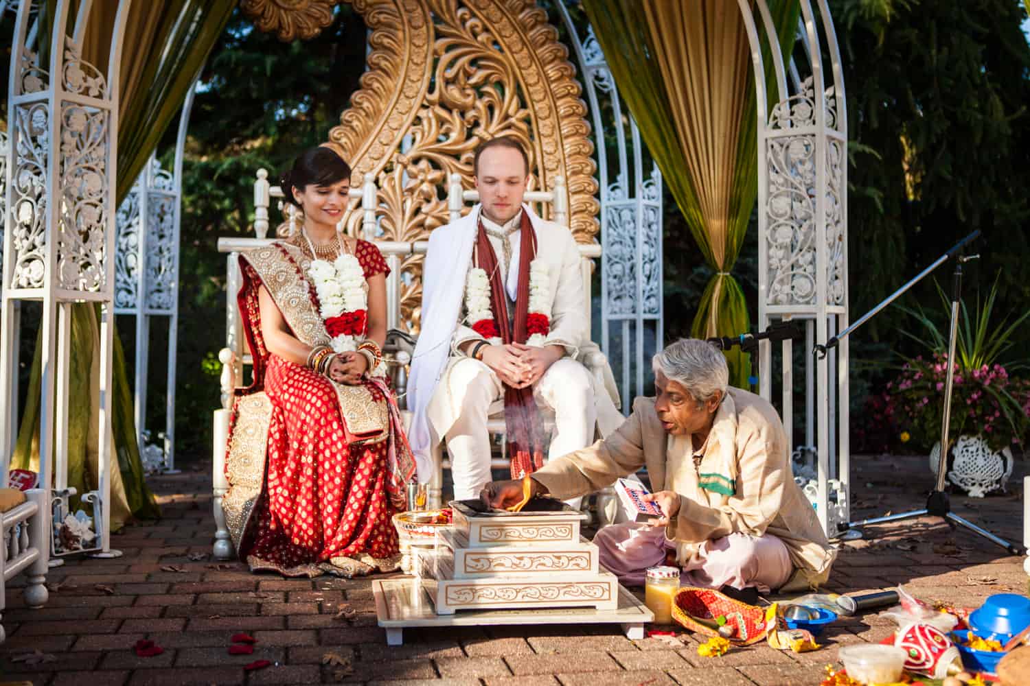 Bride and groom with priest during traditional Hindu wedding ceremony