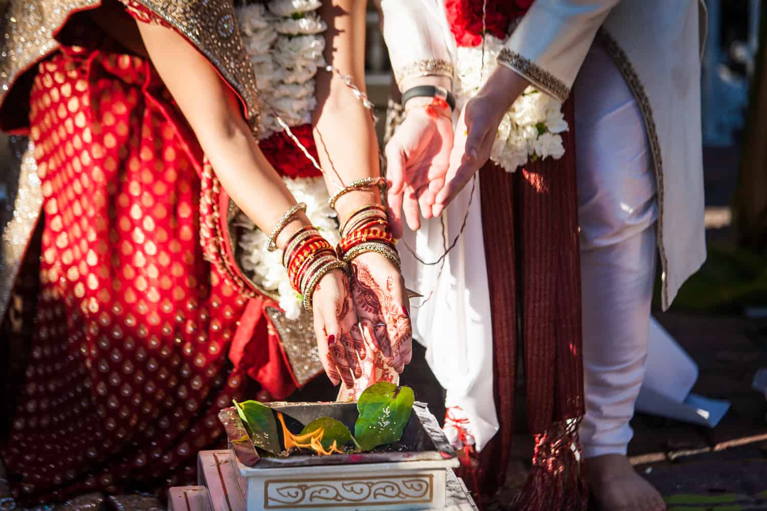 Close up on bride and groom's hands during traditional Hindu wedding ceremony