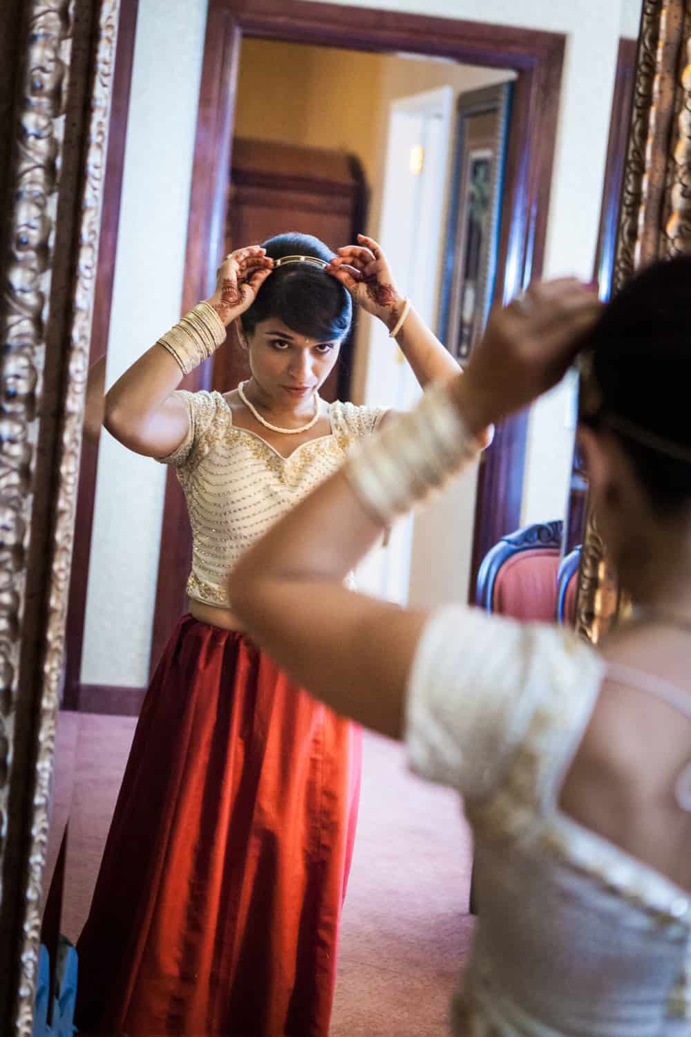 Bride adjusting hair accessory in mirror