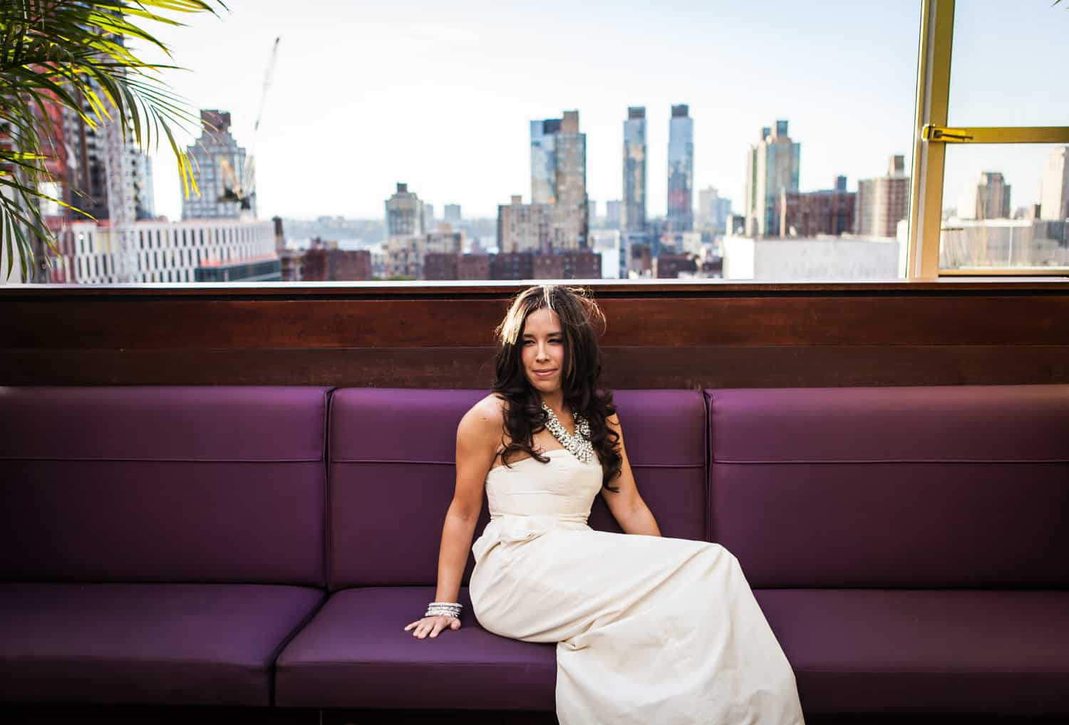 Bride sitting on bench with view of Upper West Side in background