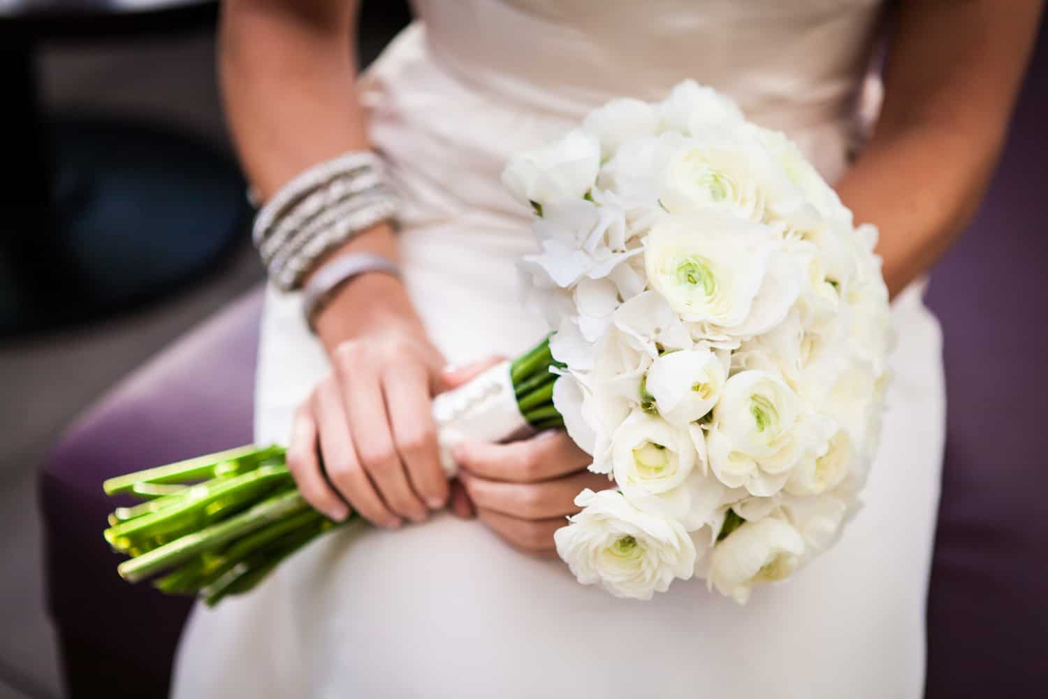 Close up of bride's hands holding flower bouquet