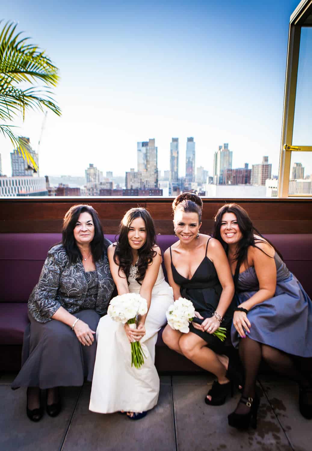 Bride and bridesmaids sitting on bench