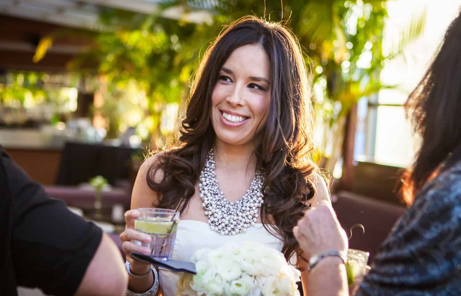 Bride with cocktail and flower bouquet in hand at an Empire Hotel rooftop wedding