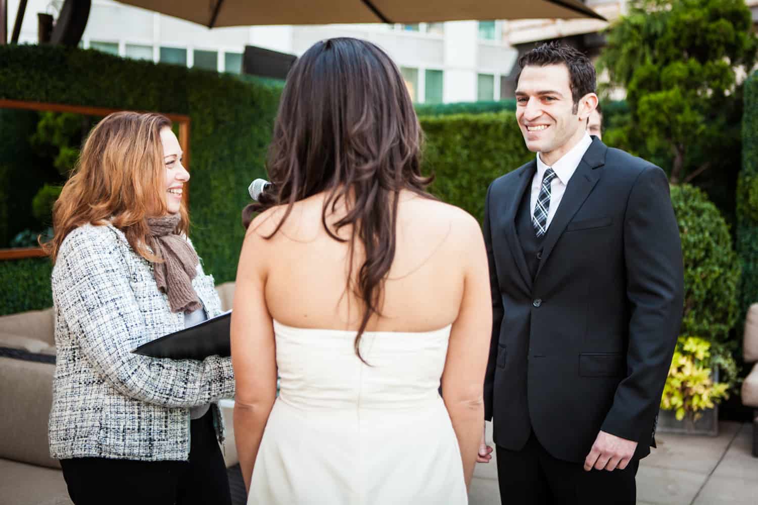 Groom seeing bride for first time during ceremony at an Empire Hotel rooftop wedding