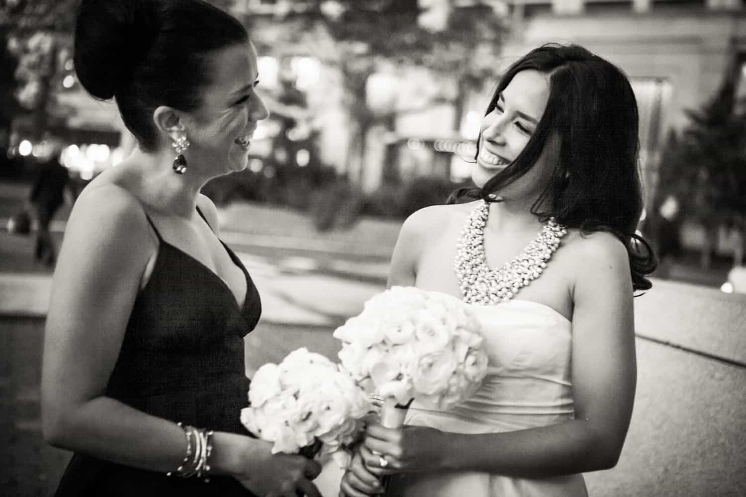 Black and white photo of bride and bridesmaid laughing