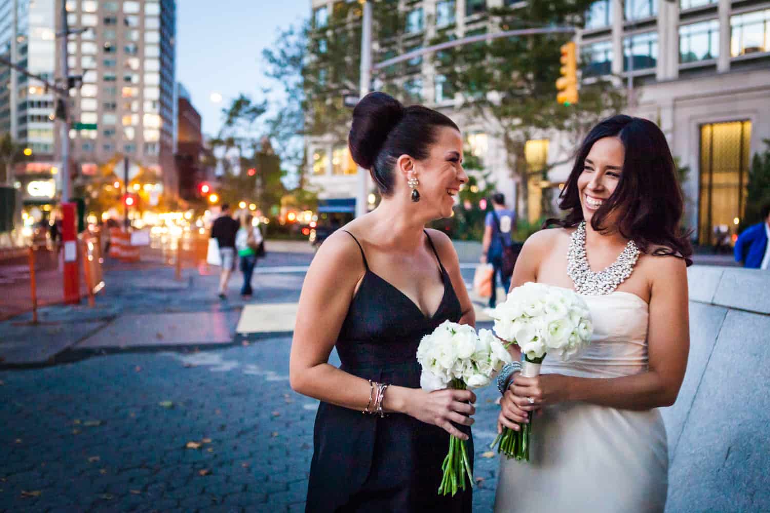 Bride and bridesmaid laughing on Upper West Side street