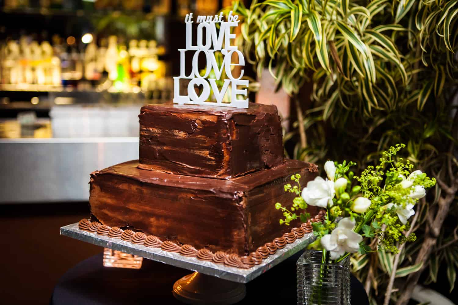 Chocolate, two-layer wedding cake with 'Love, Love, Love' topper