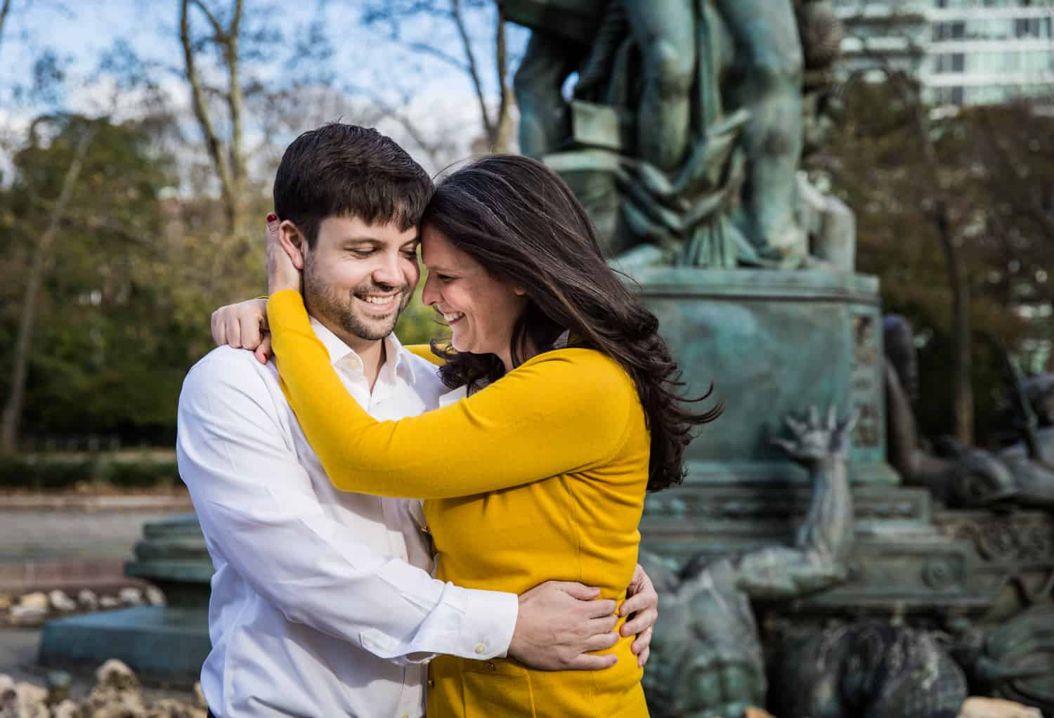 Grand Army Plaza engagement photos of couple hugging in front of fountain statue