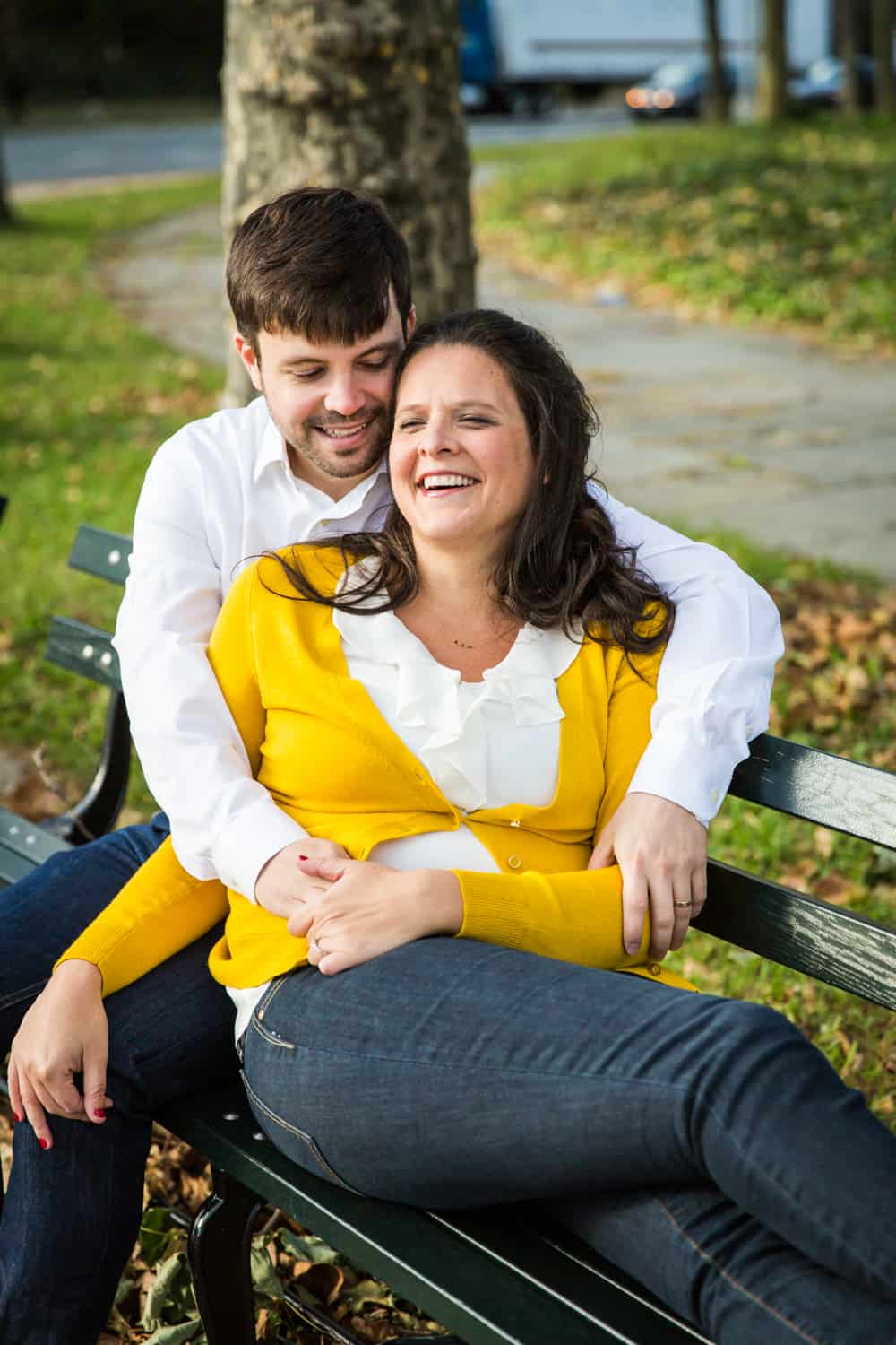 Grand Army Plaza engagement photos of couple laughing on bench
