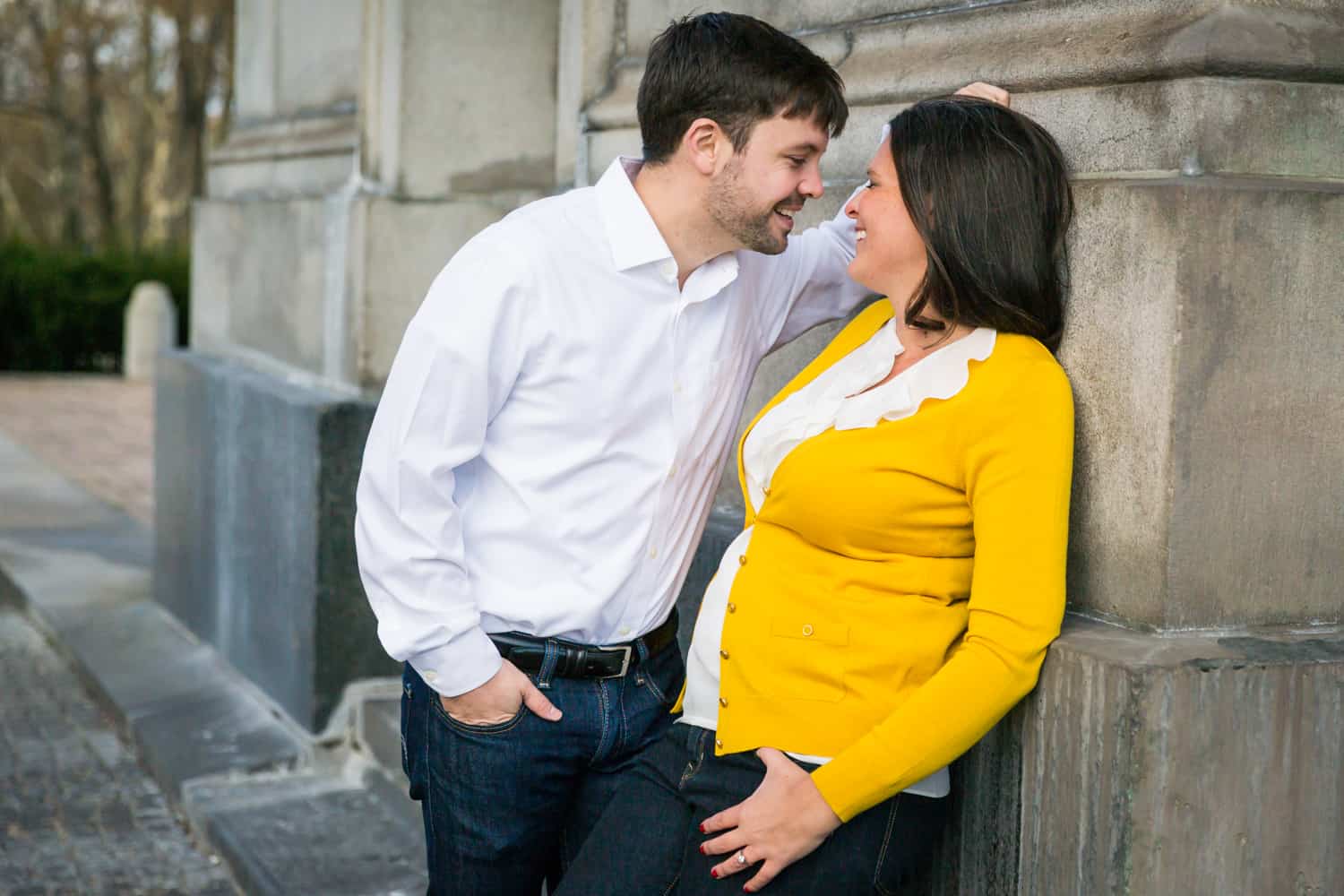 Grand Army Plaza engagement photos of couple leaning against arch